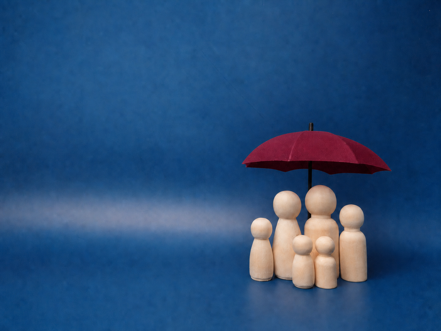 A family sheltered under an umbrella, symbolising protection of wealth