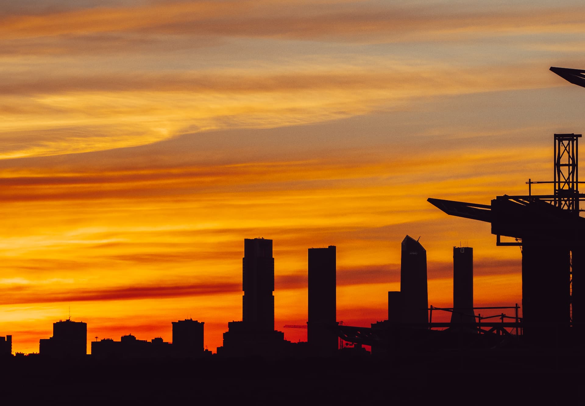 City skyline silhouetted against a vibrant sunset