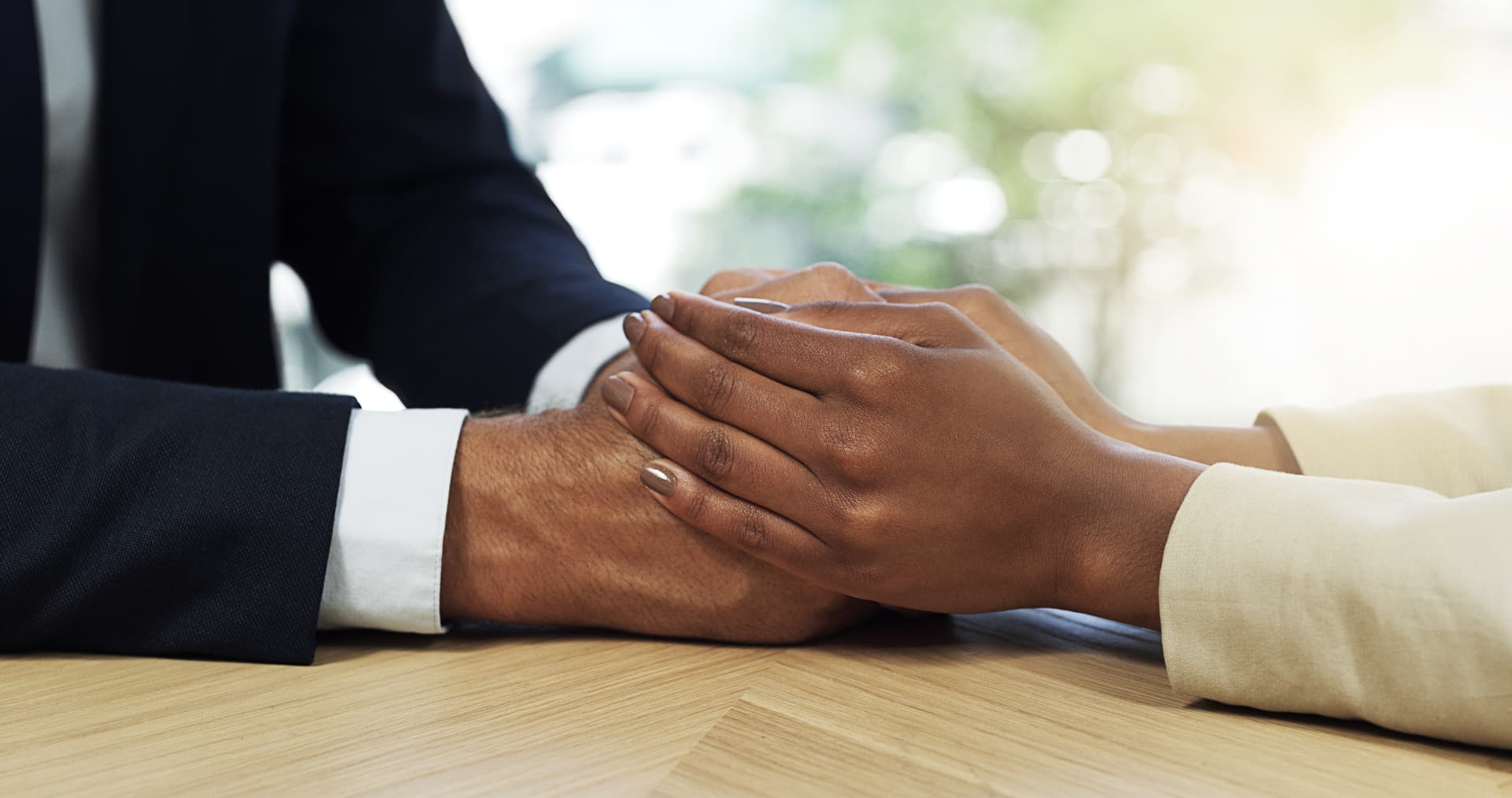 A professional offering reassuring counsel to a client across a meeting table